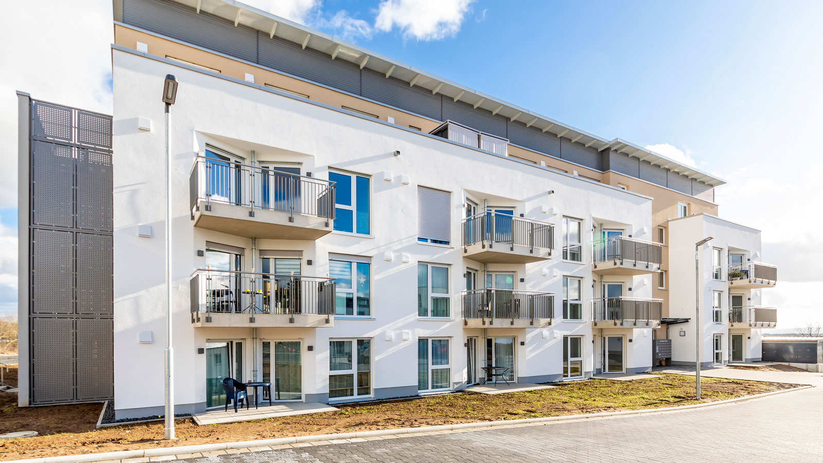 Mehrgeschossiger Wohnkomplex mit Balkonen und hellen Fassaden.