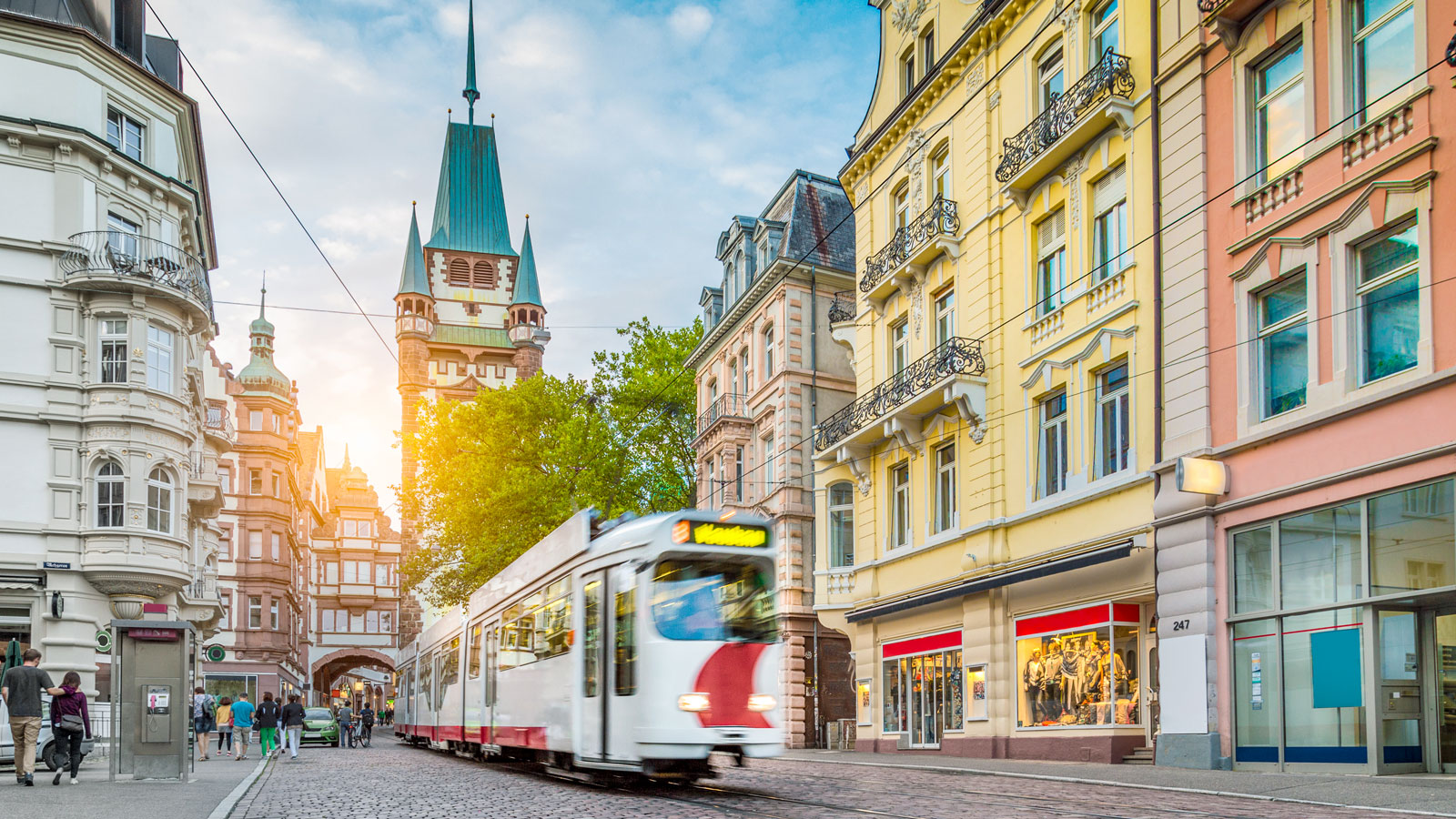 Straßenbahn fährt durch historische Altstadt mit Fachwerkhäusern.