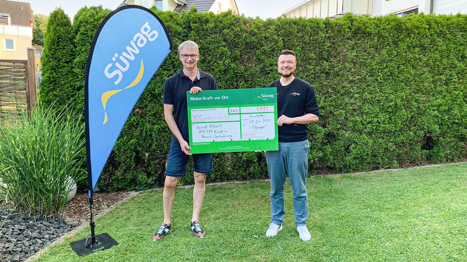 Mann mit Werbeaufsteller "Meine Kraft vor Ort" im Freien.