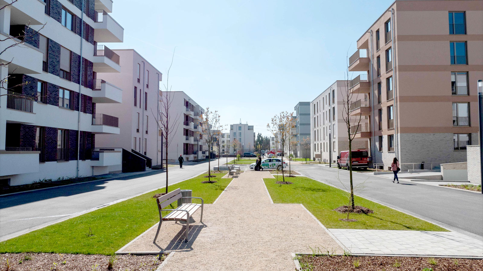 Wohngebiet mit modernen Häusern, Rasenflächen und Fußweg.