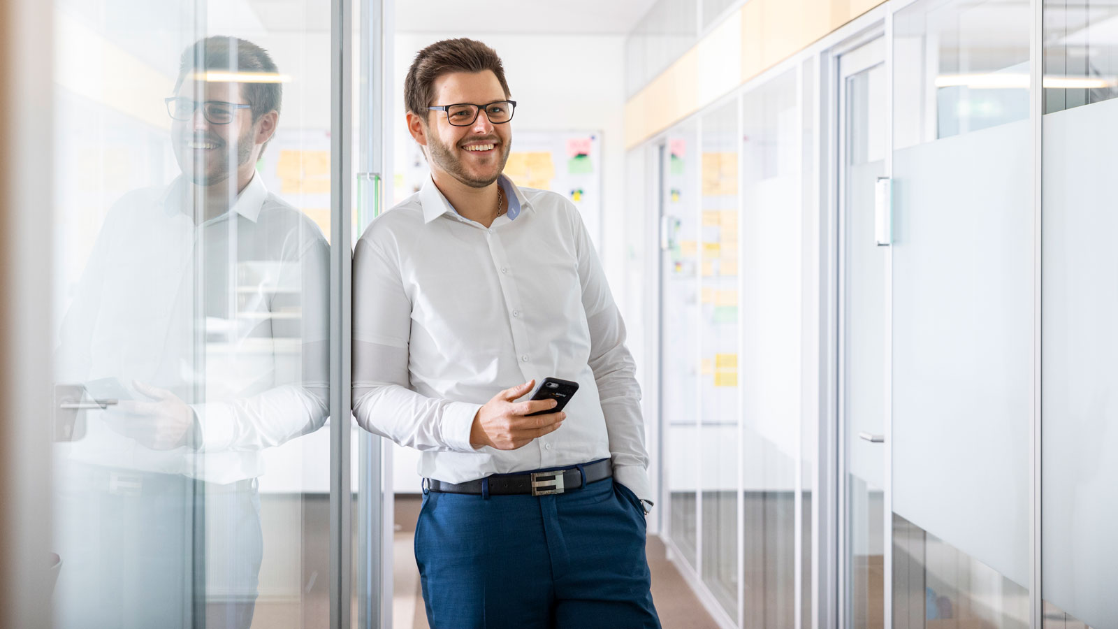 Mann mit Smartphone im Büro