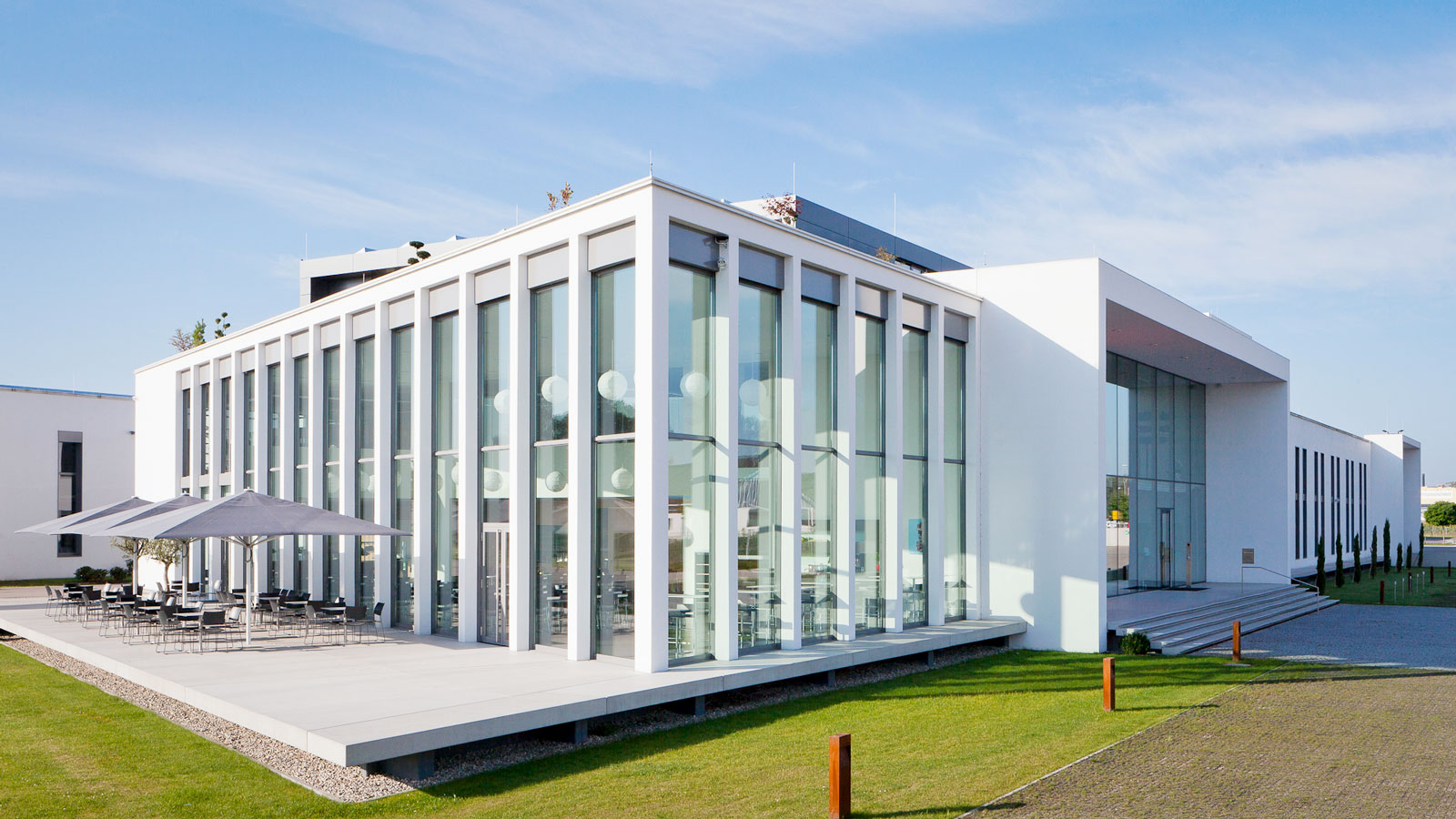 Modernes Bürogebäude mit Glasfassade und Terrasse.