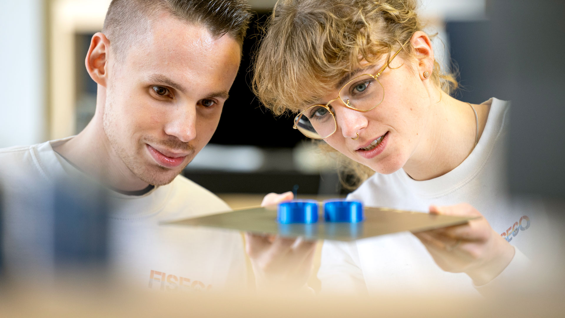 Zwei Personen untersuchen ein blaues Modell eines Herzens.