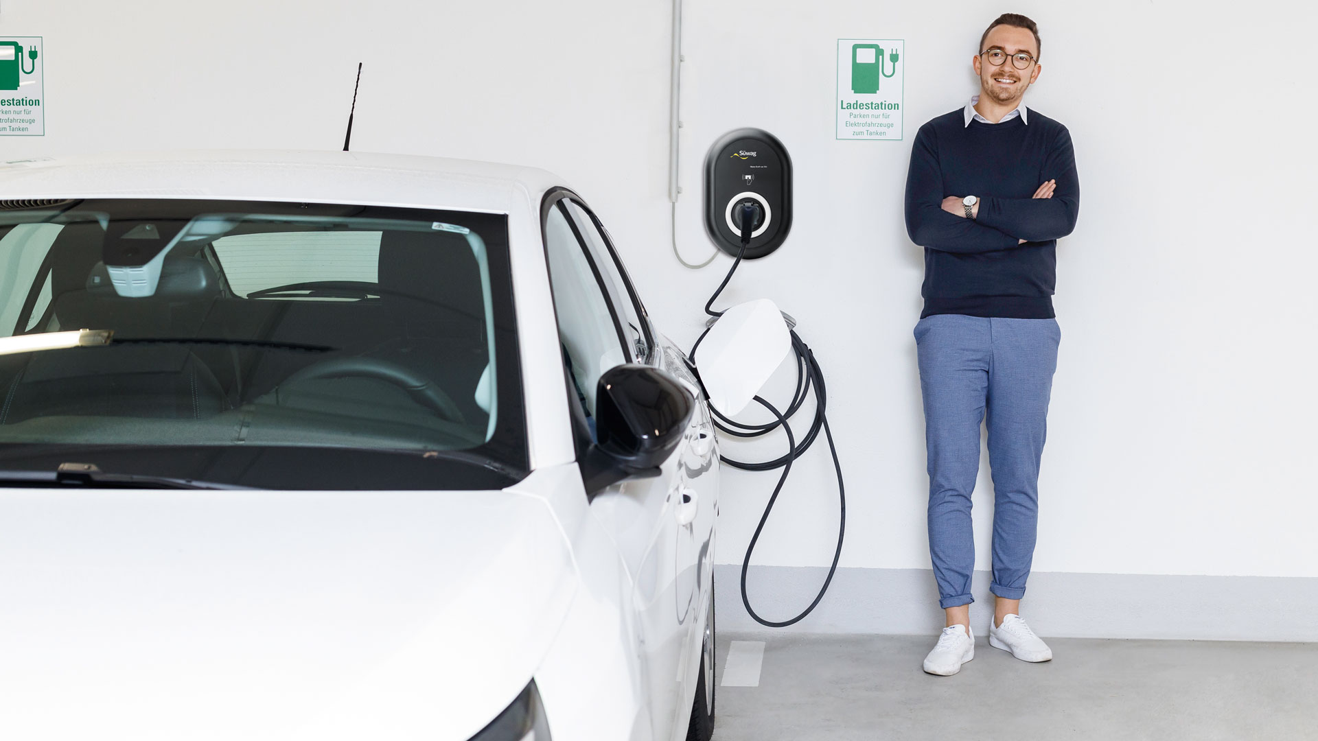 Elektrischer Wagen wird an Ladestation angeschlossen.