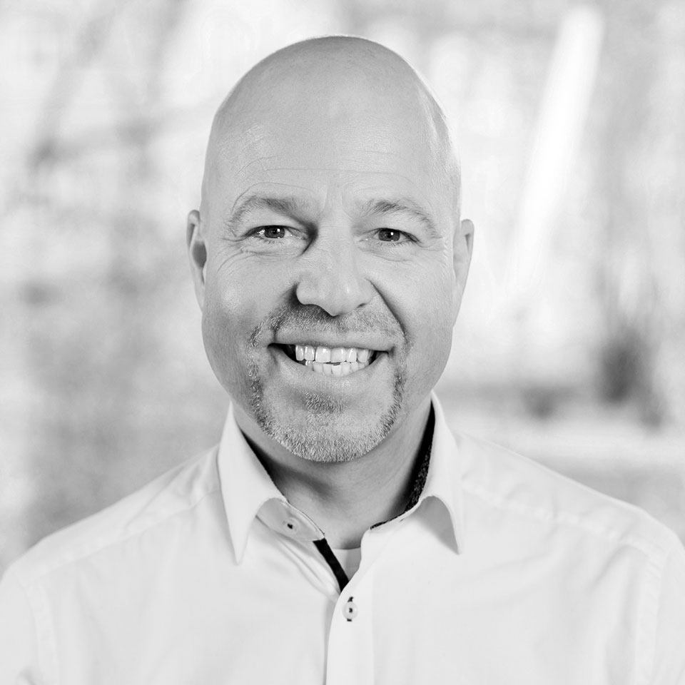 Lachender Mann mit grauem Bart und Hemd