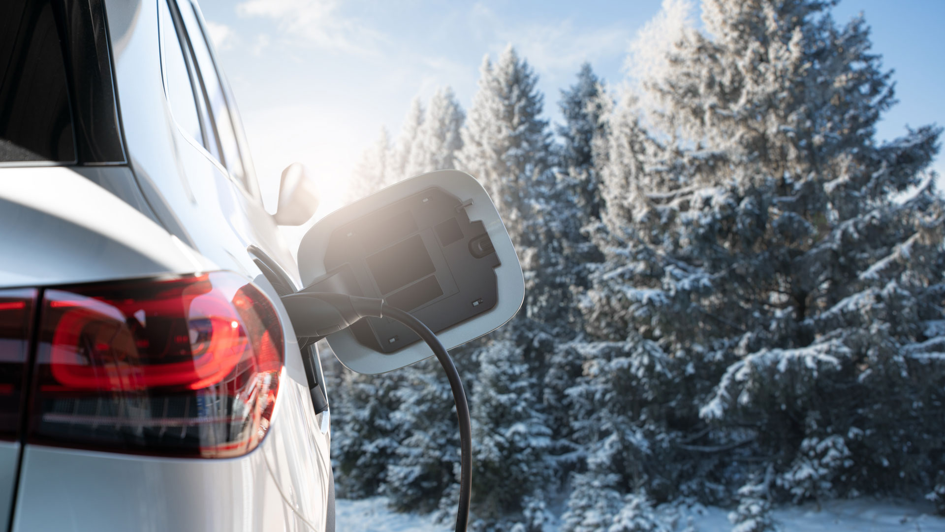 Elektroauto wird im Winter an Ladestation angeschlossen.