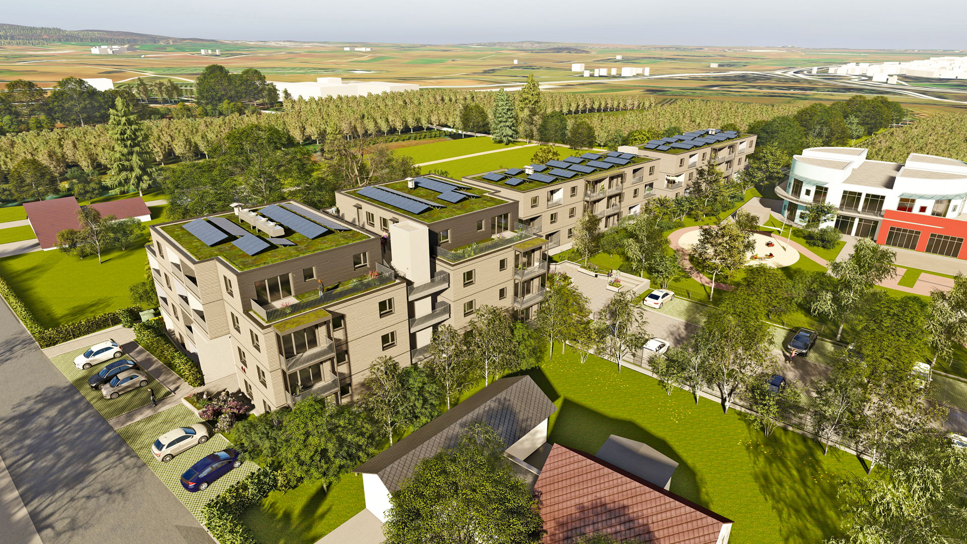 Mehrgeschossiger Wohnkomplex mit begrünten Dächern und Solaranlagen, umgeben von Rasenflächen und Bäumen.