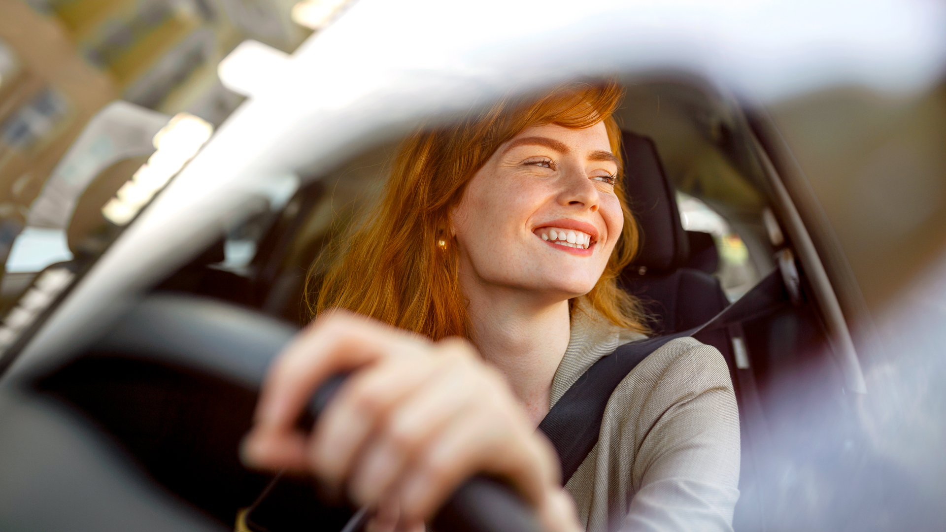 Frau lächelt beim Autofahren.