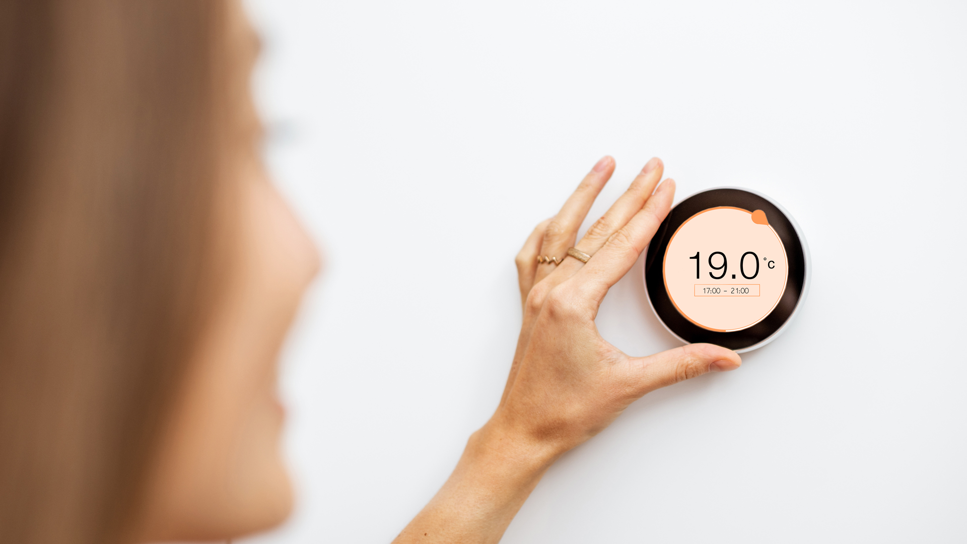 Hand hält digitales Thermostat mit Anzeige 19,0°C.