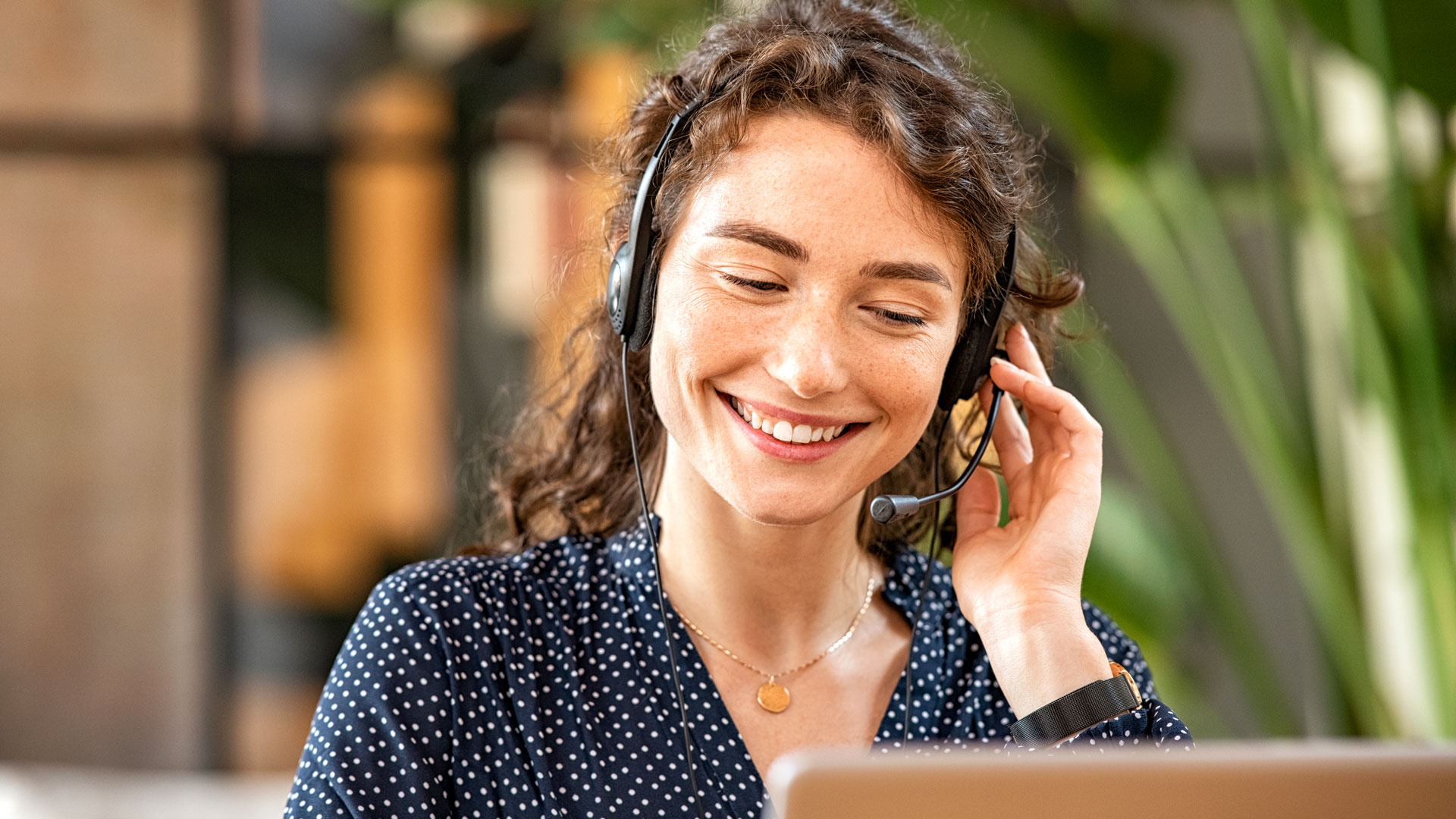 Frau mit Headset lächelt.
