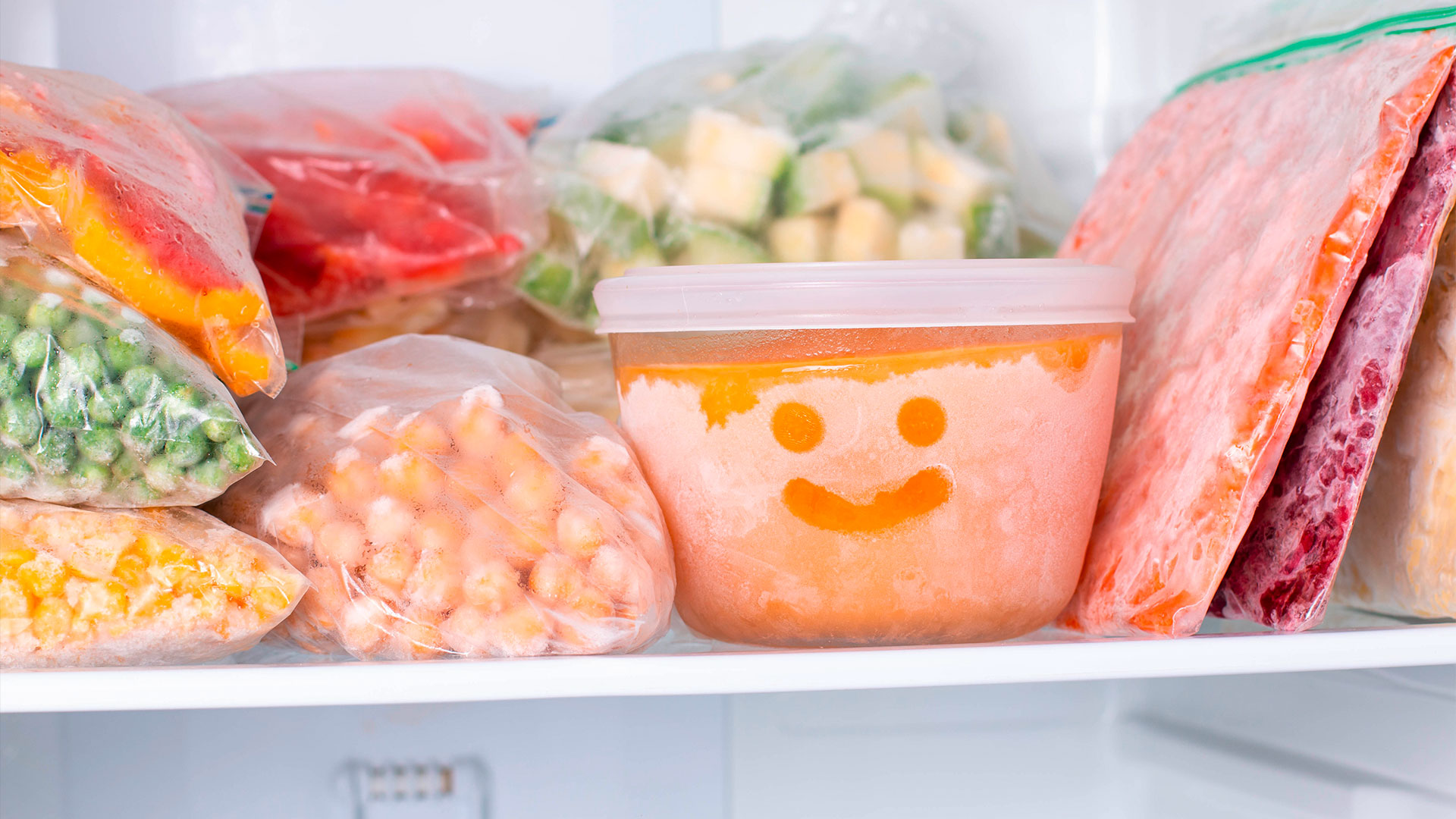 Gefrorene Lebensmittel in Plastiktüten und -behältern im Gefrierschrank.