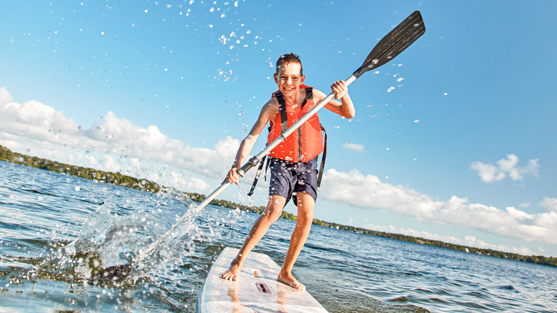 Junge paddelt auf Stand-Up-Paddleboard