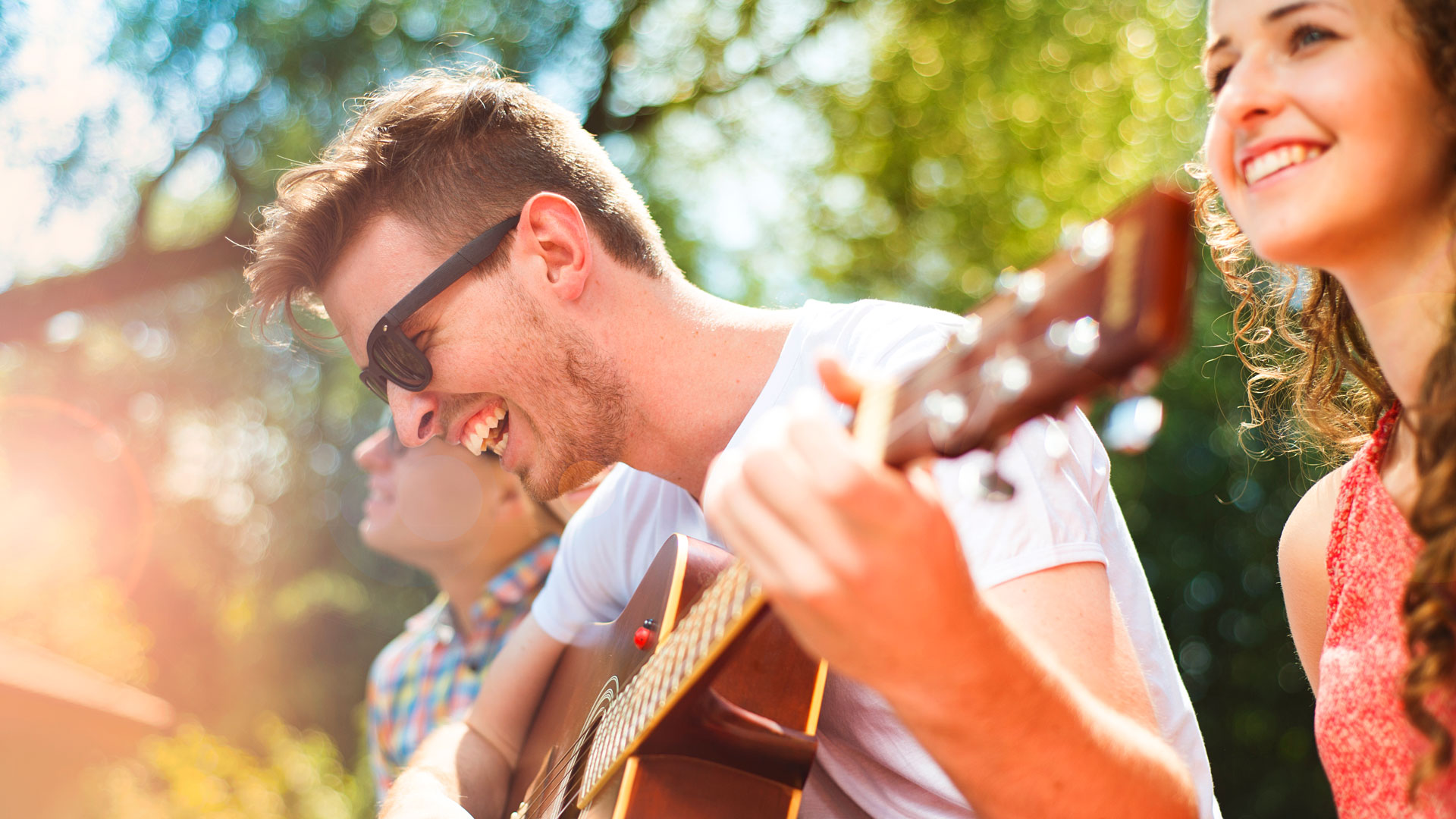 Zwei Personen spielen Gitarre im Freien.