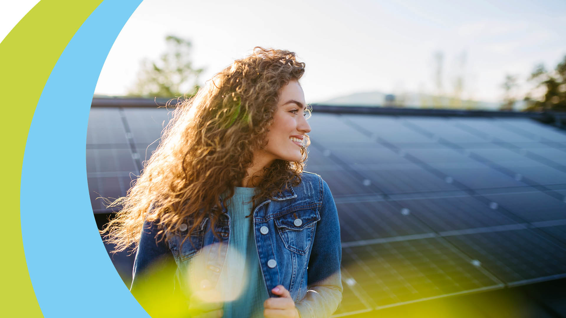 Junge Frau mit gelocktem Haar und Jeansjacke blickt nach rechts.