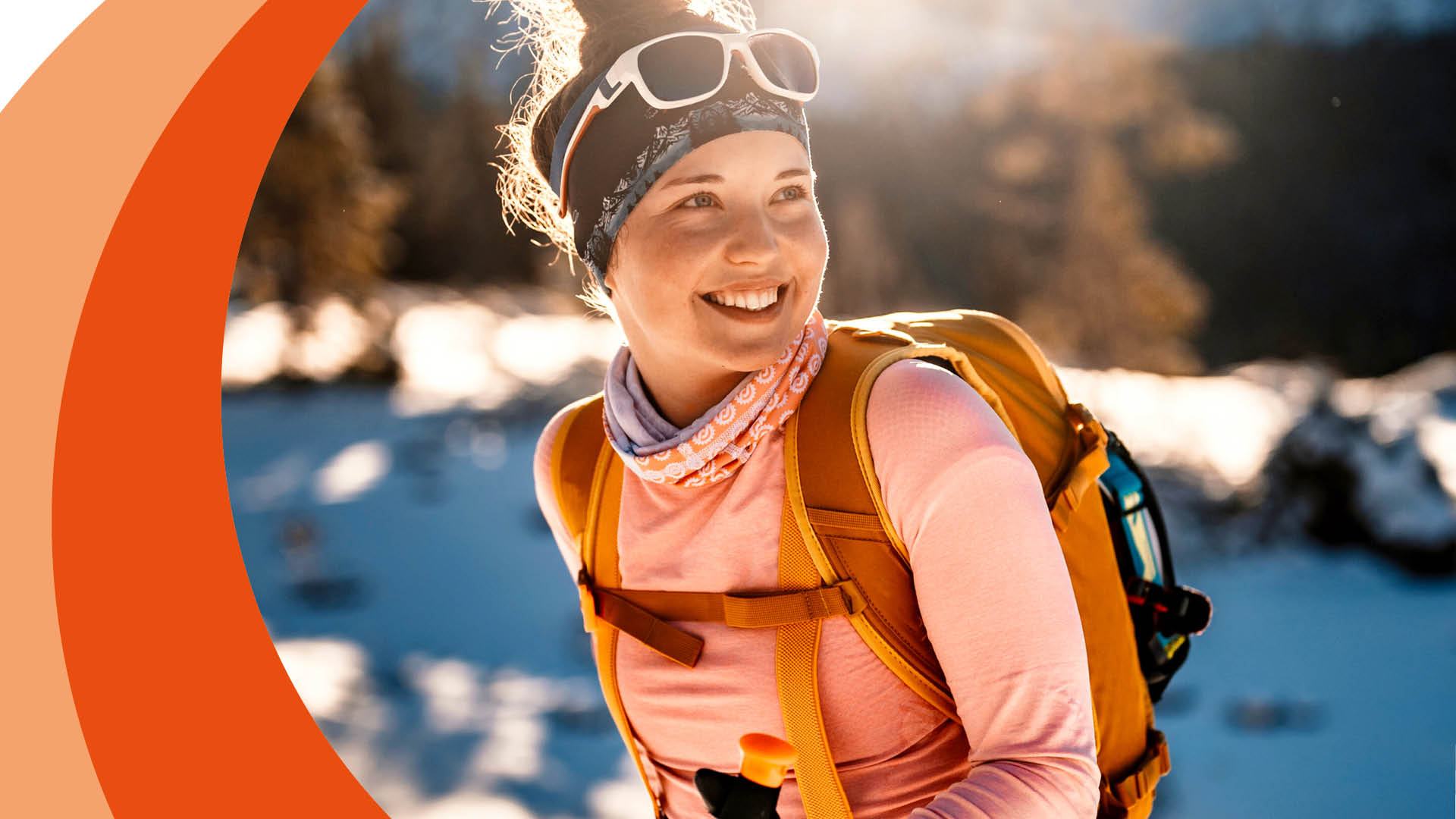 Frau mit Rucksack wandert im Schnee.